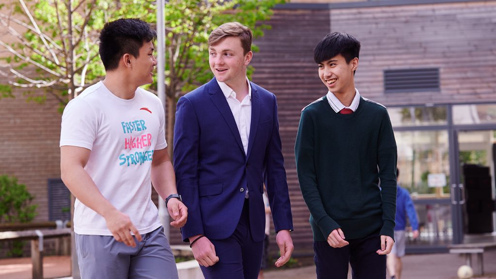 گروهی از دانشجویان پسر در حال قدم زدن در حیاط کمبریج کالج ابی