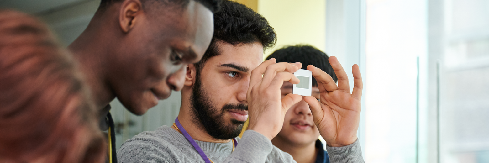 Students Examining Slide In Science Class