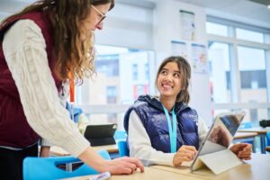 Female student talking with a teacher in psychology A-Level class at Abbey College Cambridge