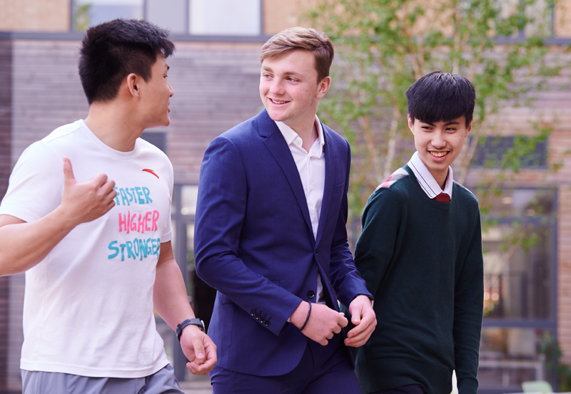 Male Students Walking In The Abbey College Cambrdieg Courtyard