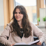 Female Student Relaxing In Common Room