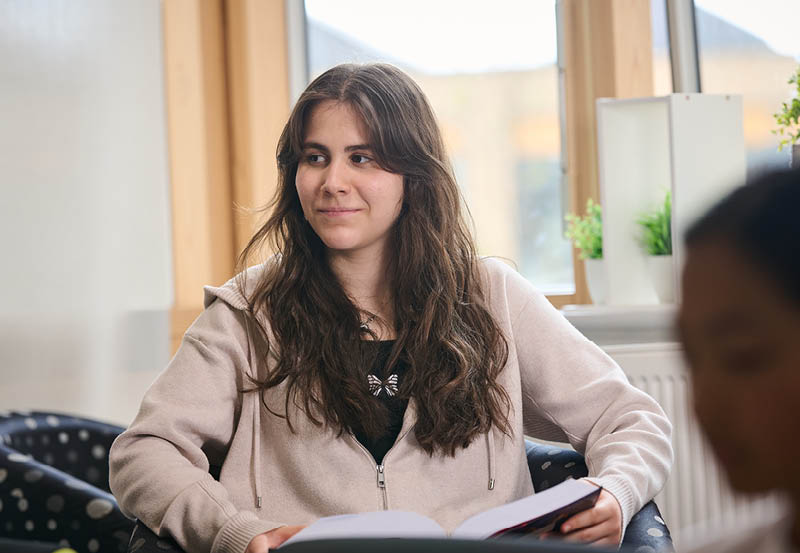 Female Student Relaxing In Common Room